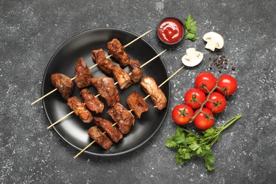 Delicious shish kebabs served on grey textured table, flat lay