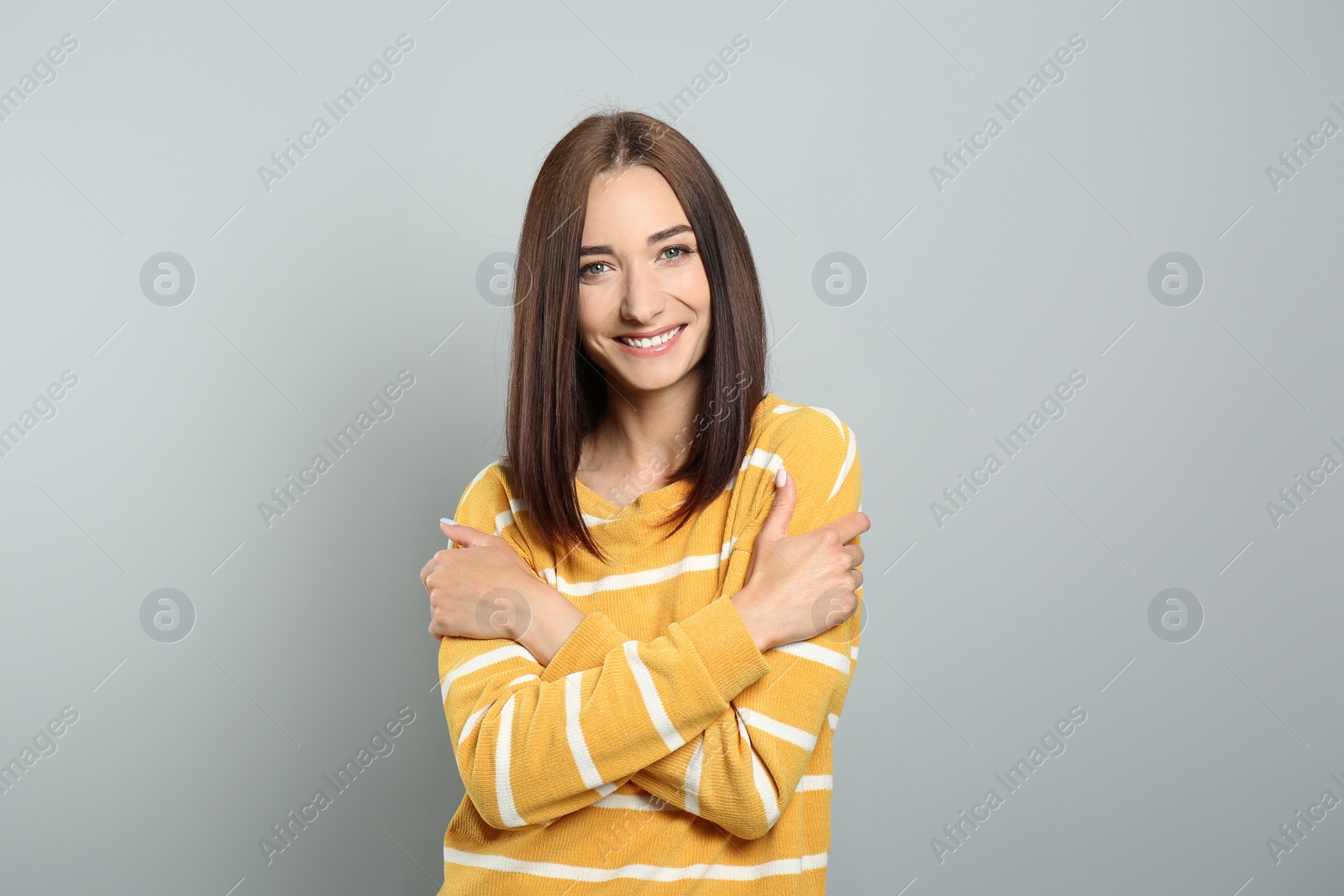 Photo of Portrait of pretty young woman with gorgeous chestnut hair and charming smile on light grey background