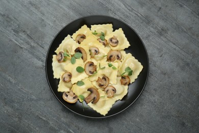 Delicious ravioli with mushrooms on grey table, top view