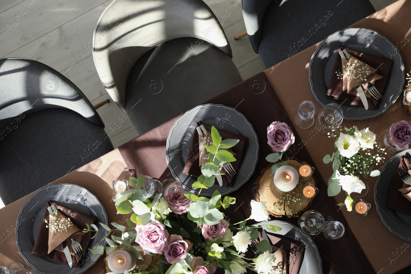 Photo of Festive table setting with beautiful tableware, candles and floral decor indoors, top view