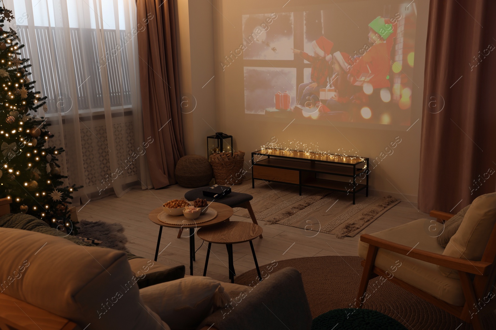 Photo of Video projector with Christmas movie in cosy room. Winter holidays atmosphere