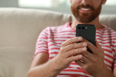 Photo of Man using smartphone at home, closeup view. Space for text