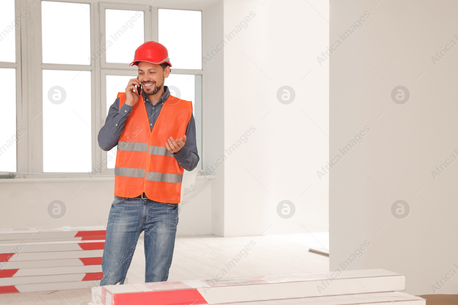 Photo of Male industrial engineer in uniform talking on phone indoors