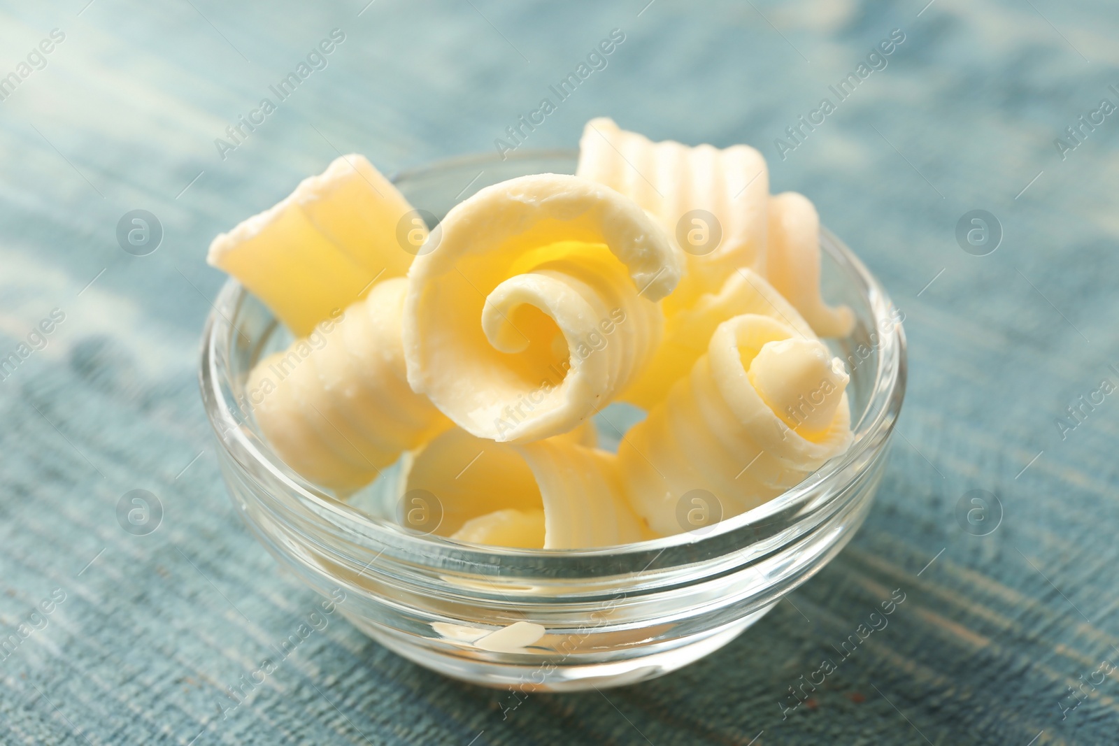 Photo of Gravy boat with butter curls on table, closeup