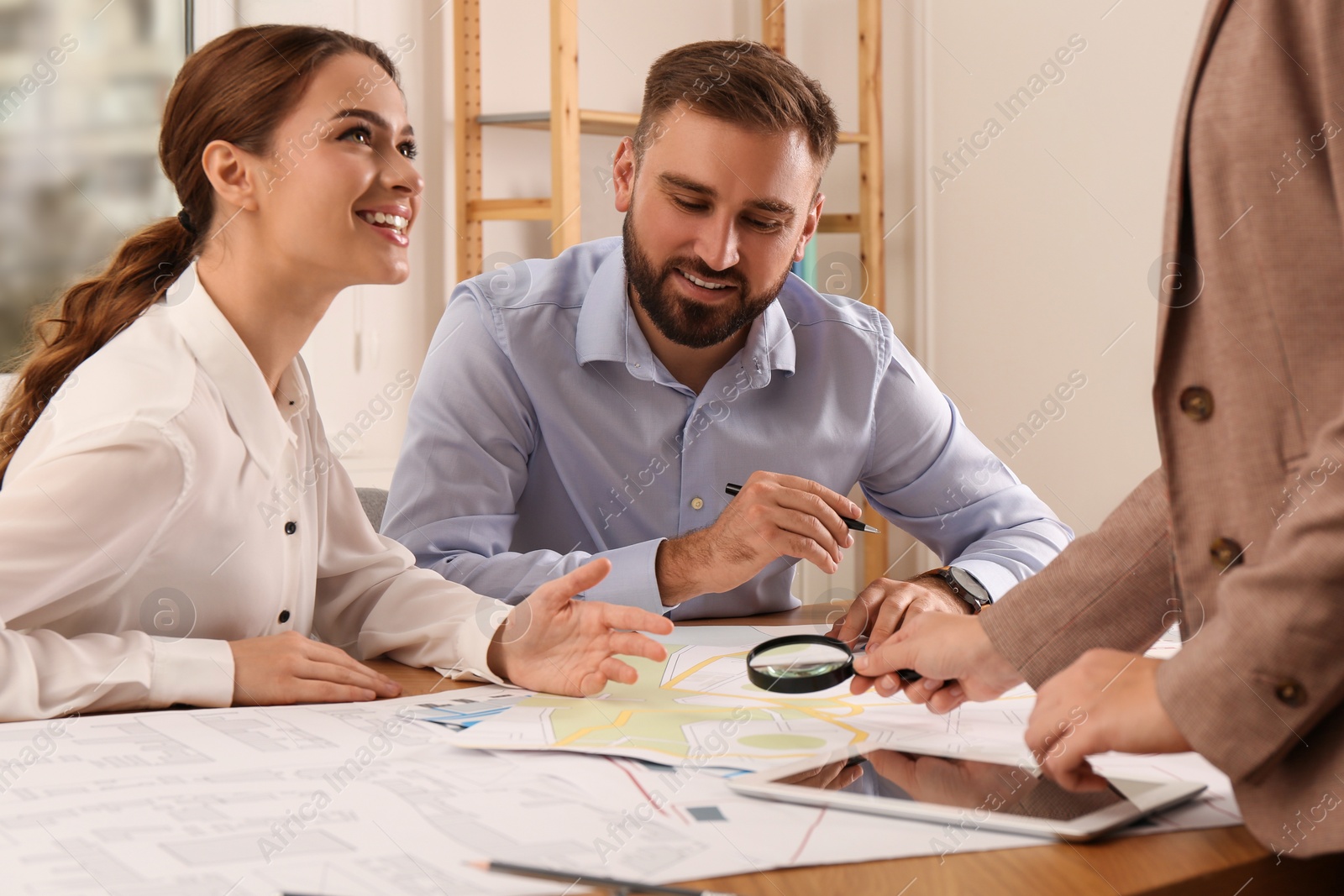 Photo of Professional cartographers working with cadastral map at table in office