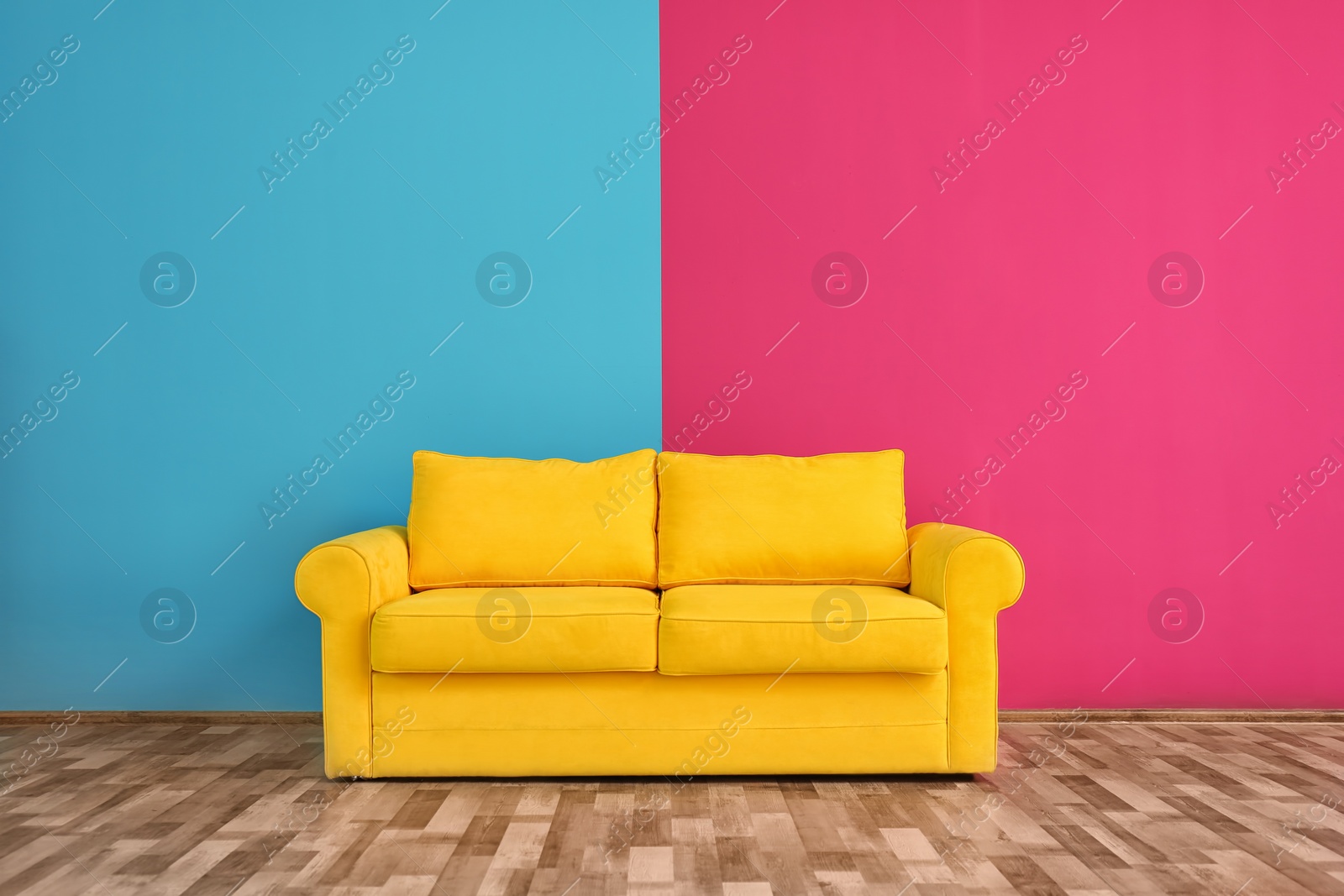 Photo of Yellow sofa near color wall in room