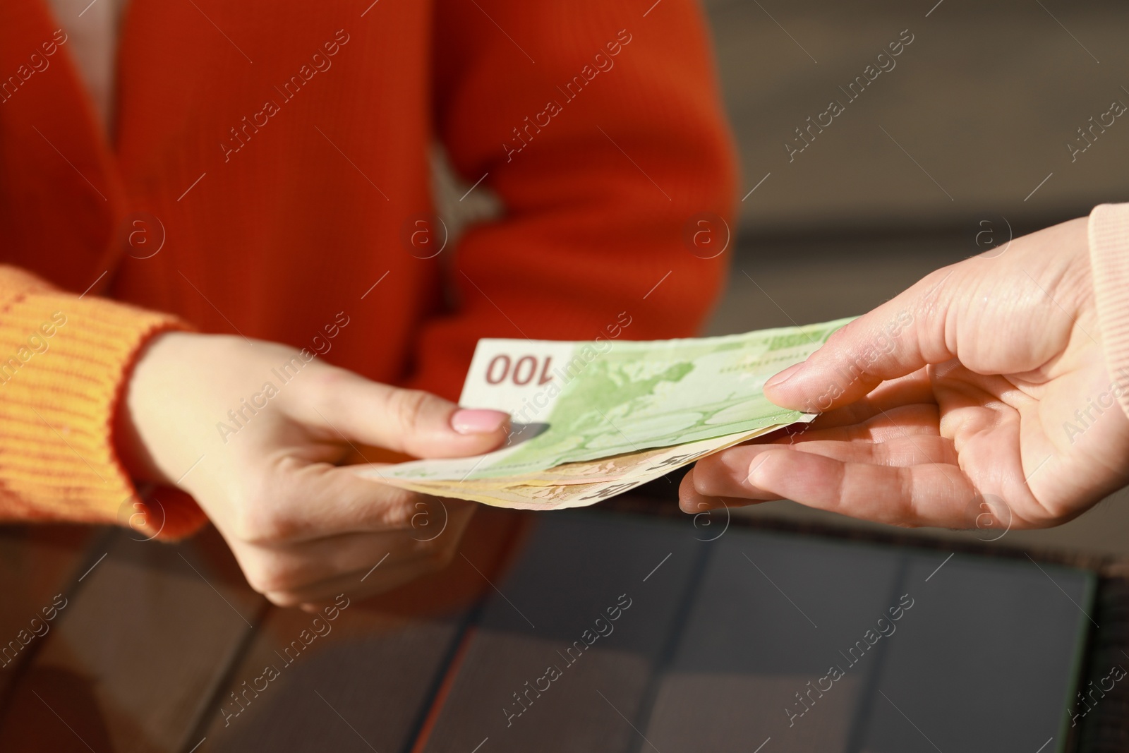 Photo of Woman paying for order to waitress at outdoor cafe, closeup. Leave tip