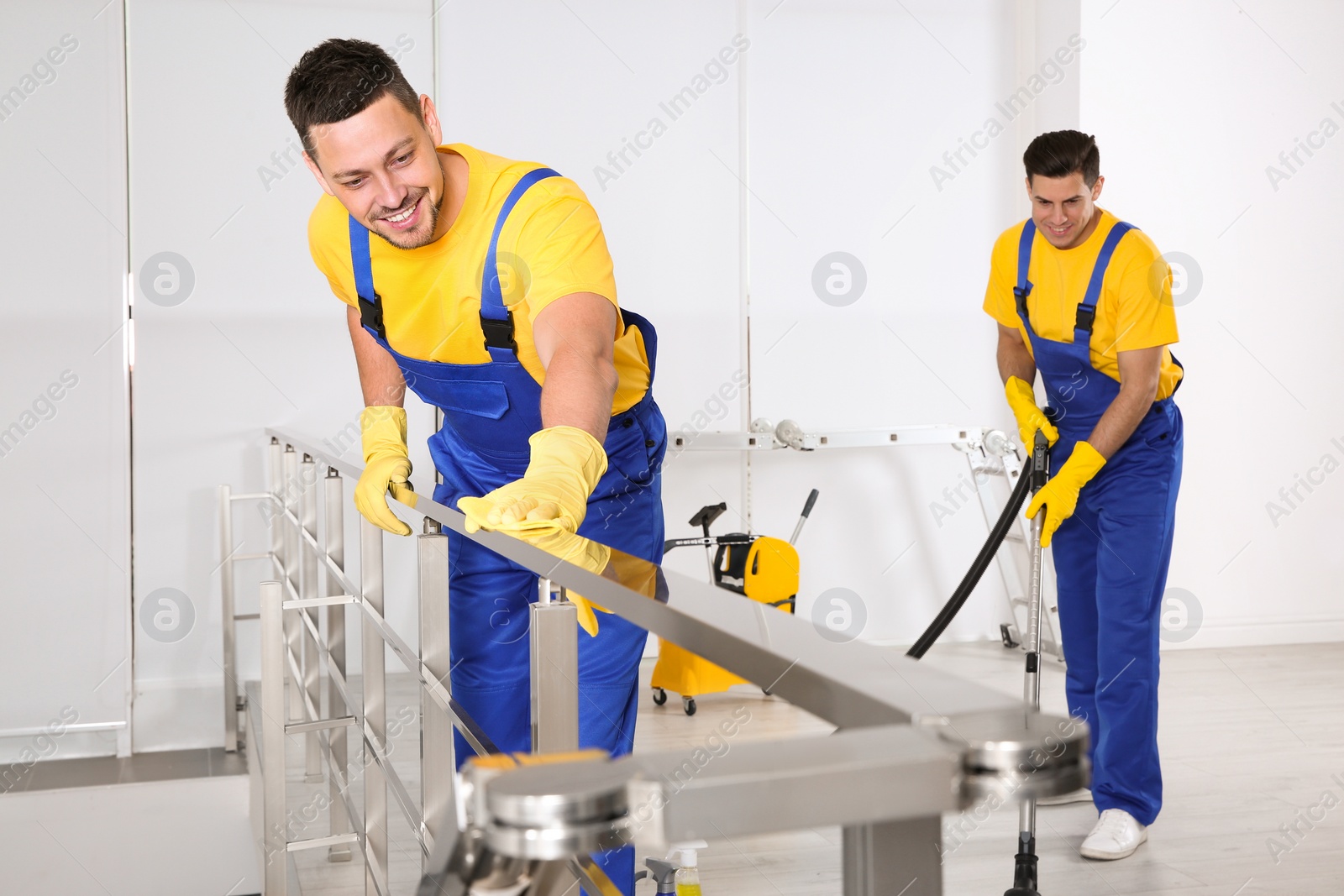 Photo of Team of professional janitors cleaning room after renovation