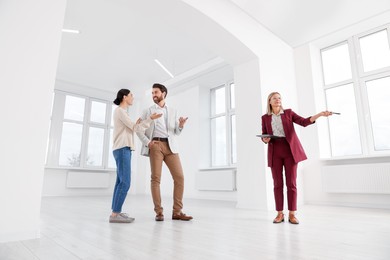 Photo of Real estate agent showing new apartment to couple