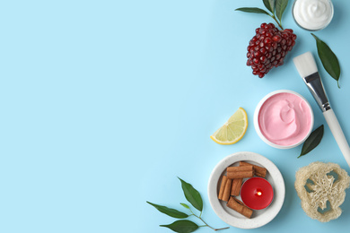 Flat lay composition with natural homemade mask, pomegranate and ingredients on blue background. Space for text