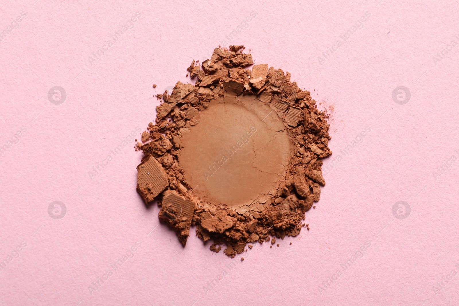 Photo of Crushed eye shadow on pink background, top view