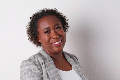 Portrait of happy African-American businesswoman on white background