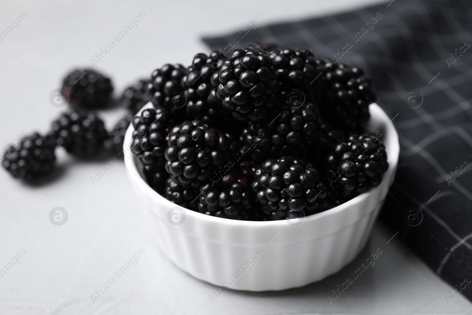 Photo of Delicious fresh ripe blackberries in bowl on table, closeup