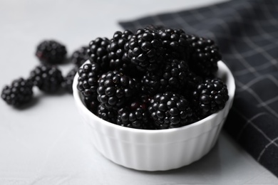 Photo of Delicious fresh ripe blackberries in bowl on table, closeup