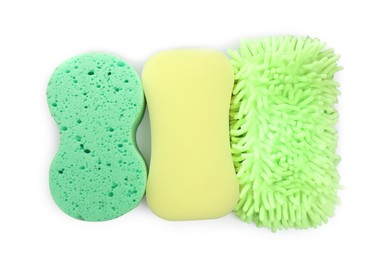 Sponges and car wash mitt on white background, top view