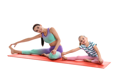 Woman and daughter doing yoga together on white background. Home fitness