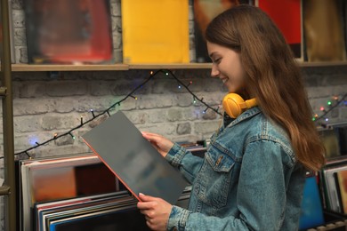 Young woman with vinyl record in store
