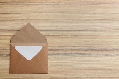 Photo of Brown paper envelope on wooden background, top view. Space for text