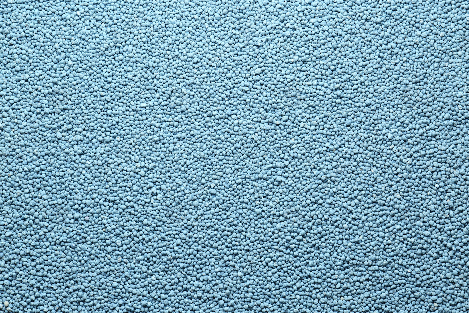 Photo of Blue granular mineral fertilizer as background, top view