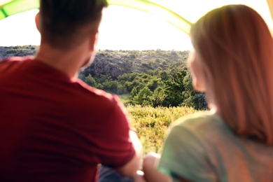 Young couple resting in camping tent, view from inside