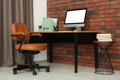 Stylish office interior with comfortable chair, desk and computer