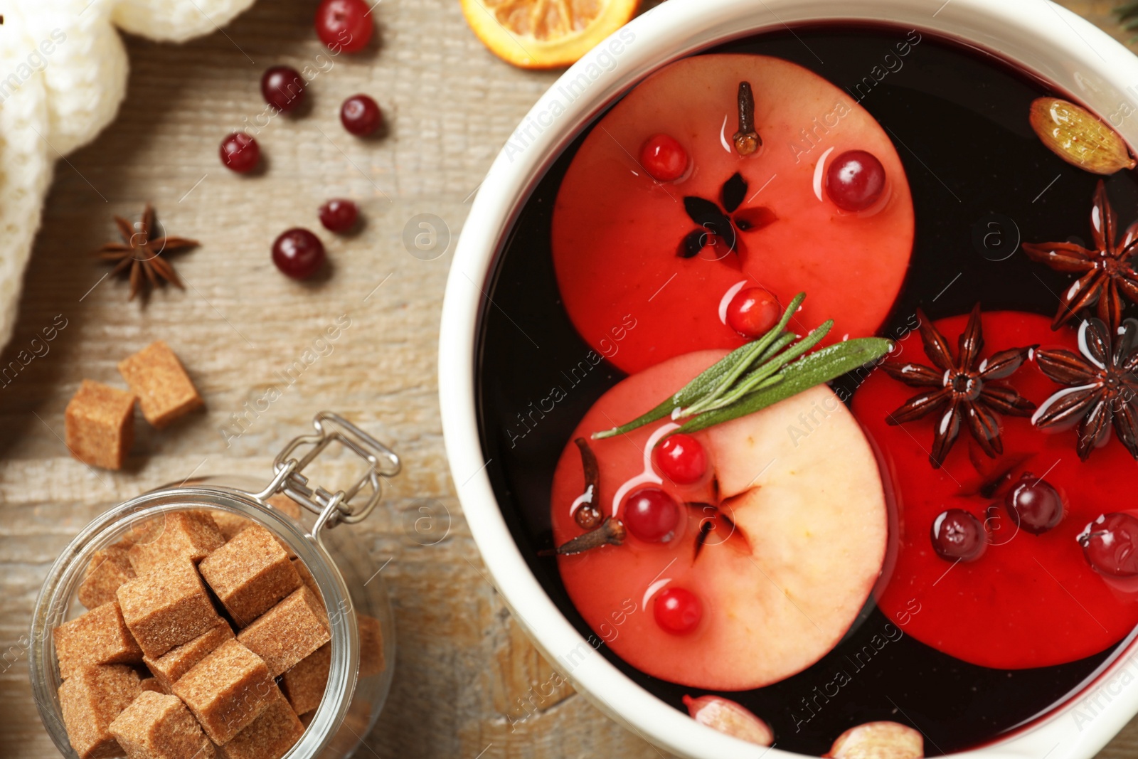 Photo of Saucepan with tasty mulled wine on wooden table, flat lay