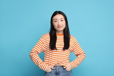 Photo of Portrait of cute woman on light blue background
