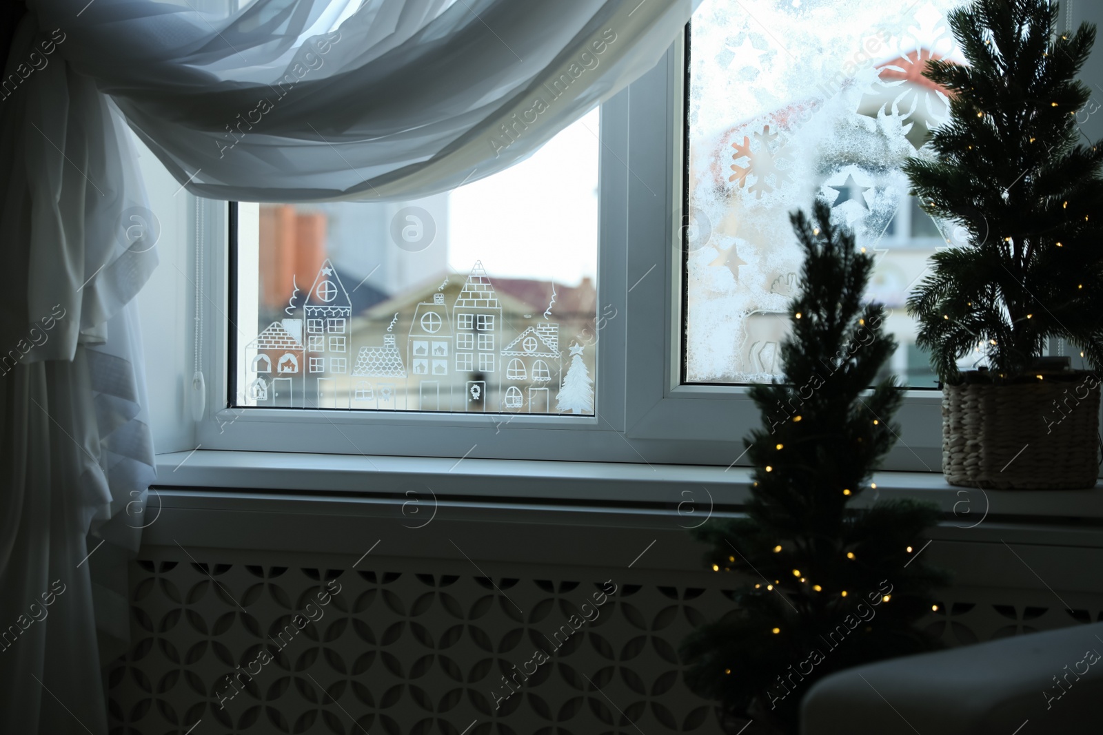 Photo of Beautiful drawing made of artificial snow on window at home. Christmas decor