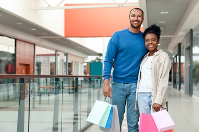 Photo of Family shopping. Happy couple with colorful bags in mall