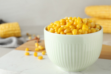 Photo of Delicious canned corn in bowl on light table, closeup