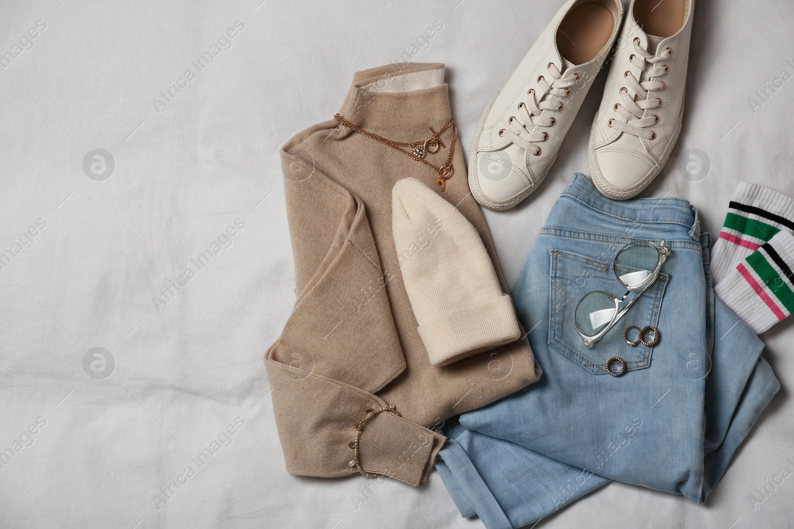 Photo of Stylish look with cashmere sweater, flat lay. Women's clothes and accessories on fabric