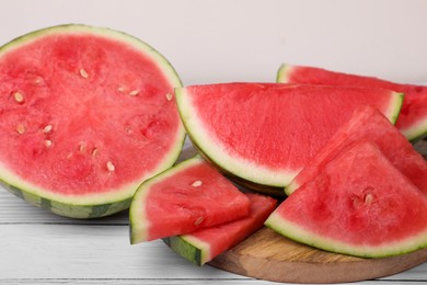 Juicy ripe cut watermelons on white table, closeup