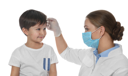 Photo of Doctor examining little boy with chickenpox on white background. Varicella zoster virus