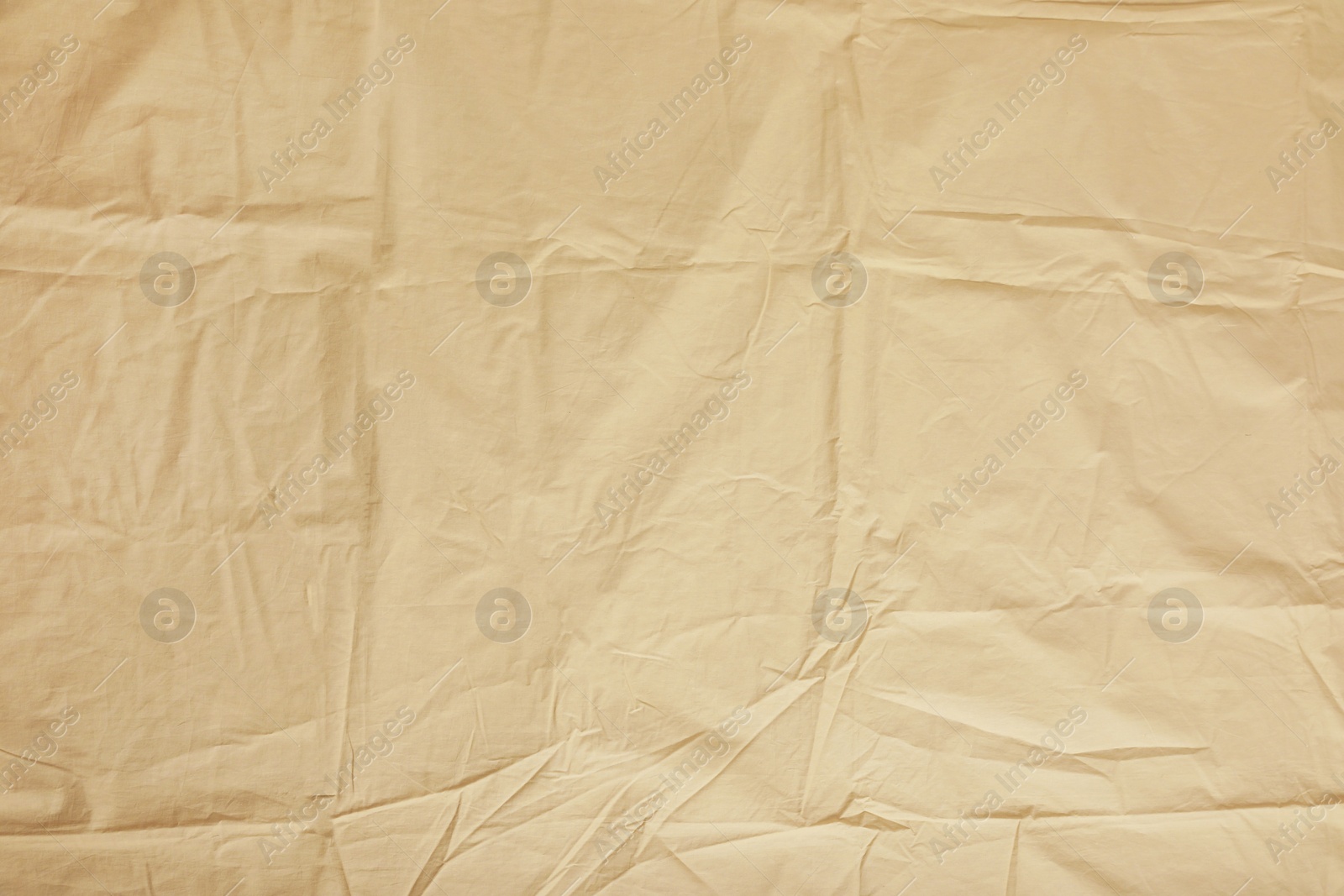 Photo of Crumpled beige fabric as background, top view