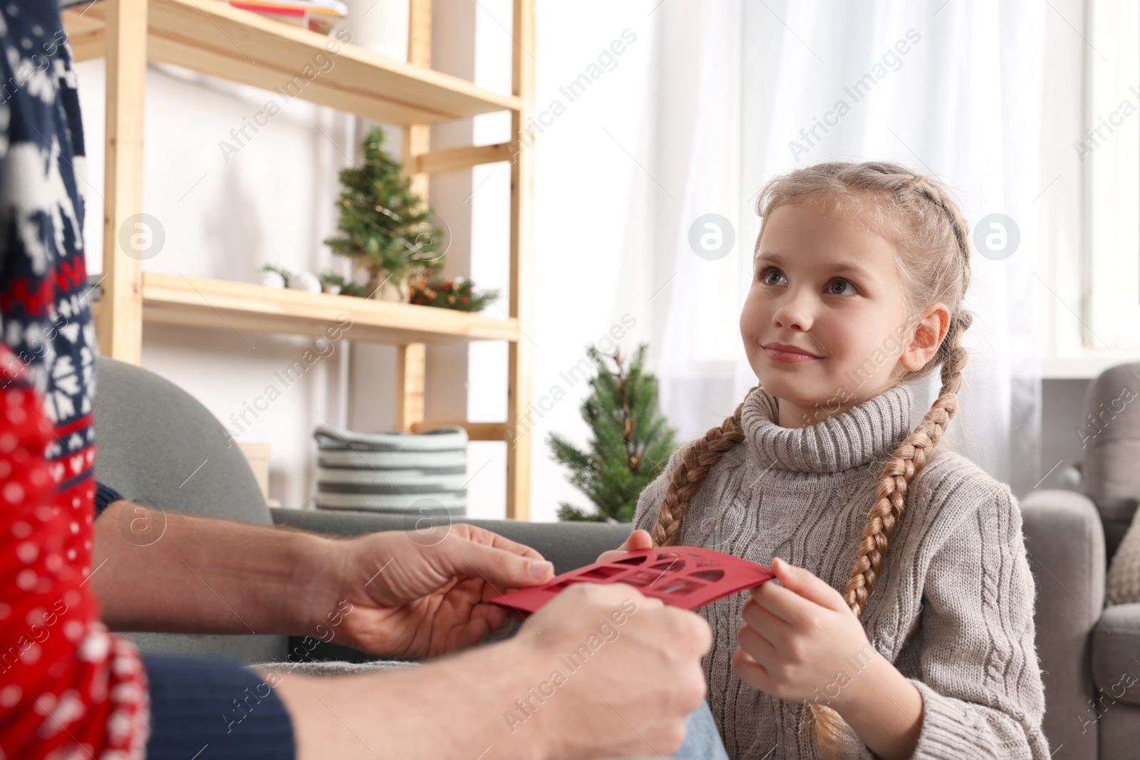 Photo of Man receiving greeting card from his daughter at home