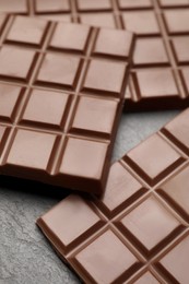 Delicious milk chocolate bars on black table, closeup