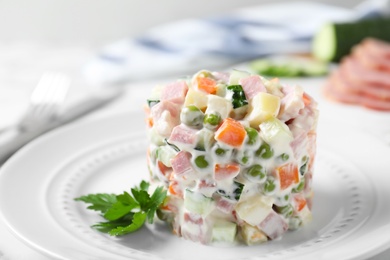 Photo of Delicious homemade salad Olivier in plate on table