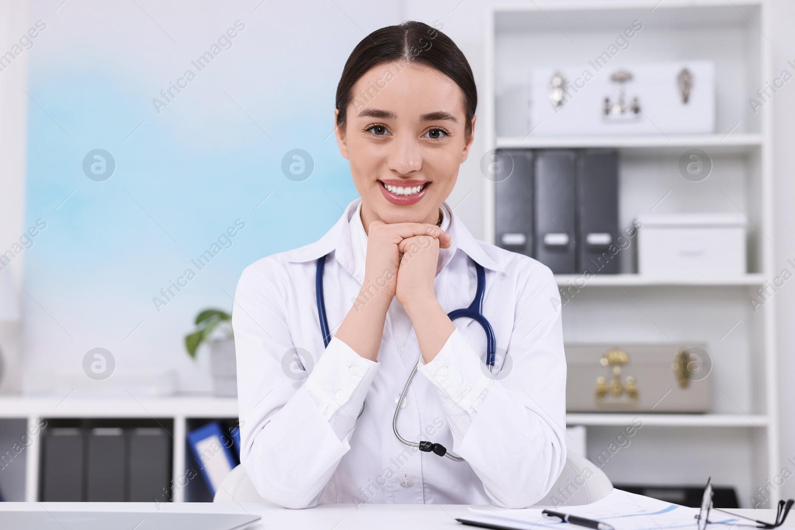 Photo of Medical consultant with stethoscope at table in clinic