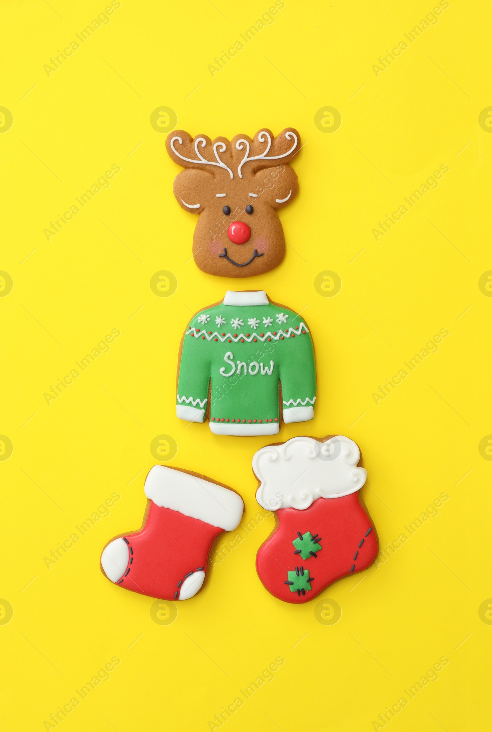 Photo of Different Christmas gingerbread cookies on yellow background, flat lay