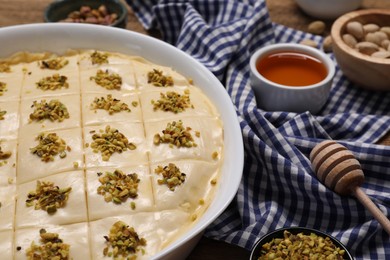 Photo of Making delicious baklava. Raw dough with ingredients on table, closeup