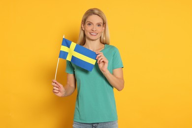 Woman with flag of Sweden on yellow background