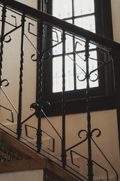 Photo of Stairs and black metal railing indoors. Interior design