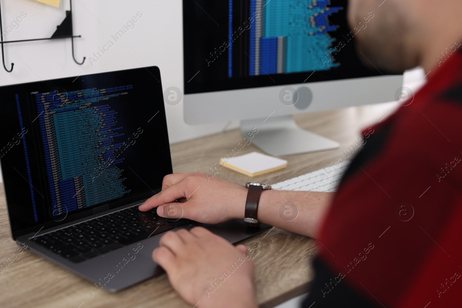 Photo of Programmer working with laptop at desk in office, closeup