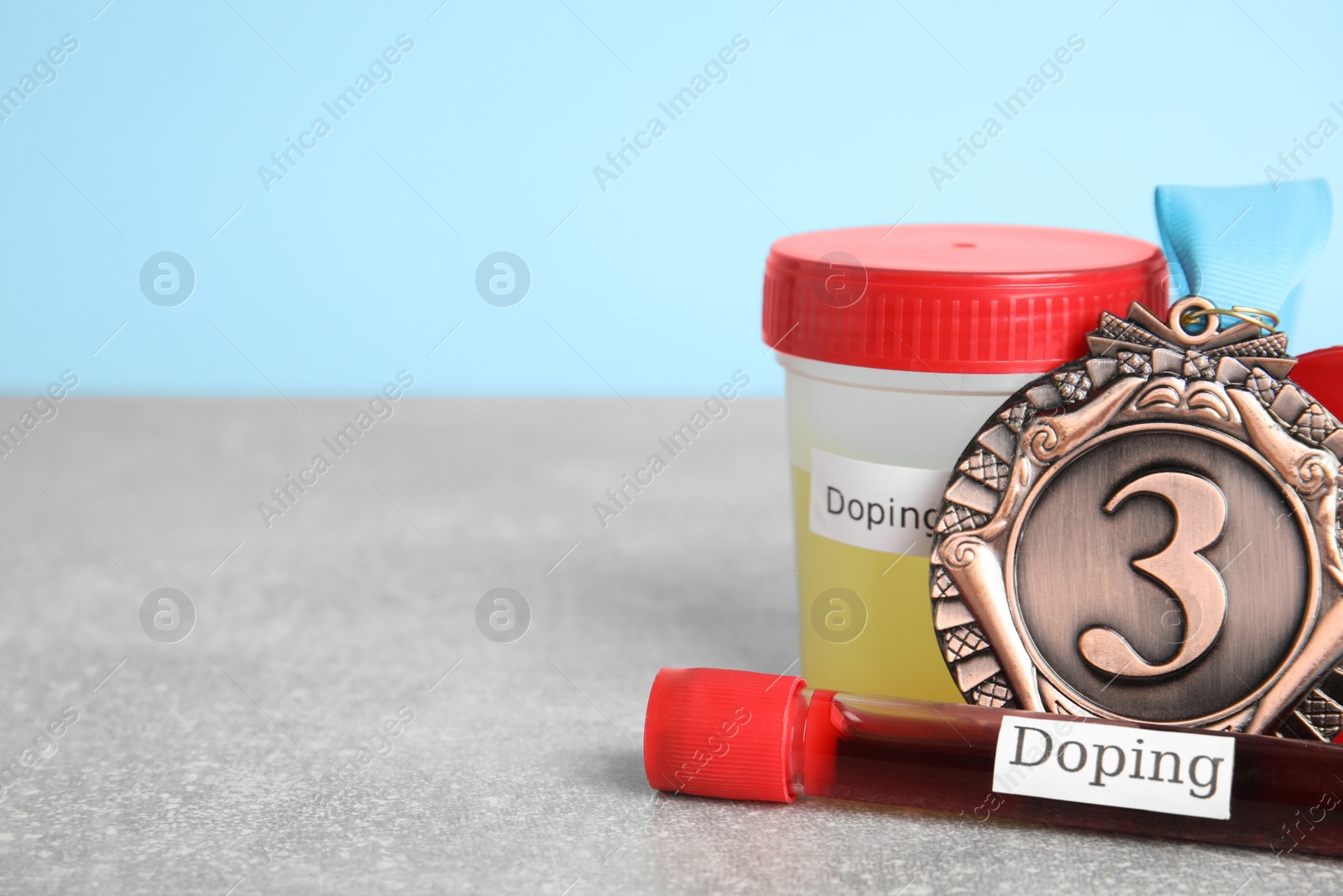 Photo of Medal, tube of blood and urine with words Doping on light grey stone background. Space for text