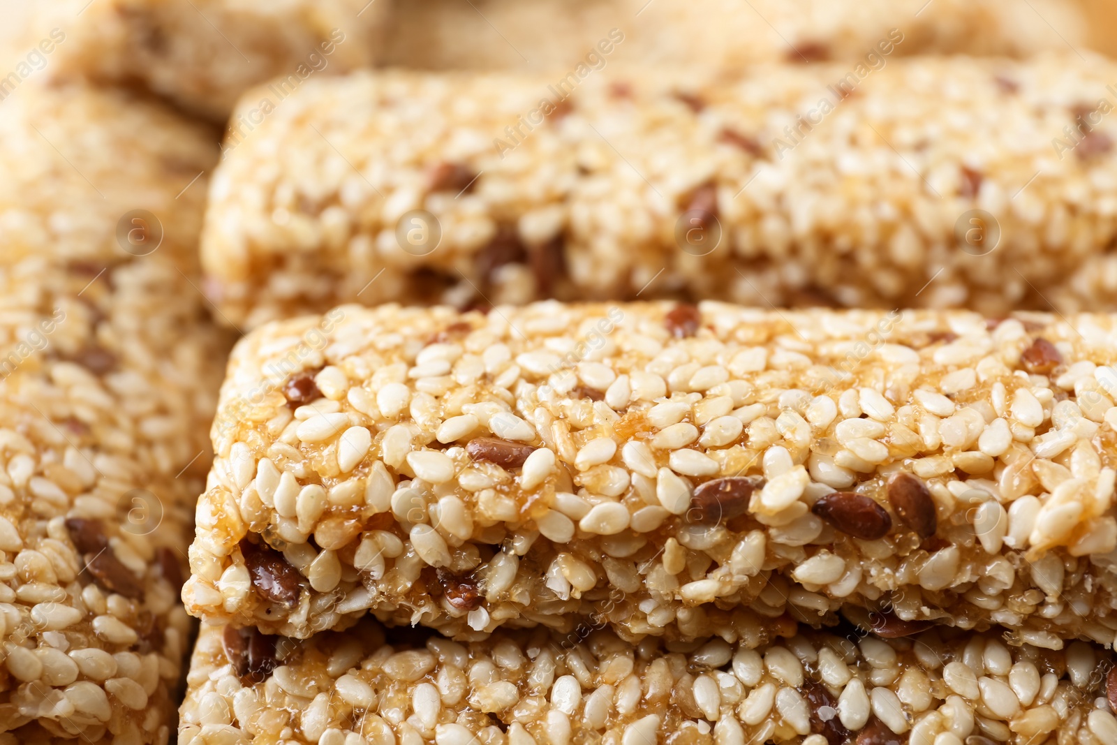 Photo of Tasty sesame seed bars as background, closeup