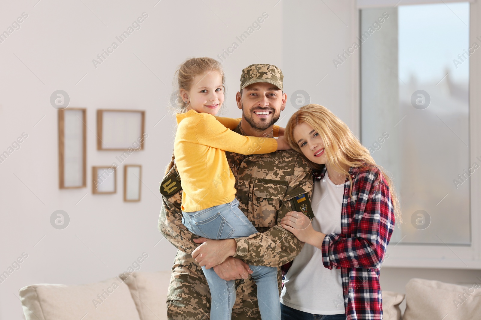 Photo of Soldier in Ukrainian military uniform reunited with his family at home
