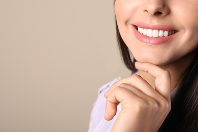 Photo of Young woman with healthy teeth on color background, closeup. Space for text