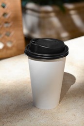 Photo of Takeaway coffee cup on beige table in cafe
