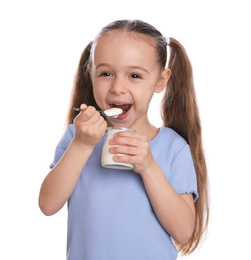 Cute little girl eating tasty yogurt on white background