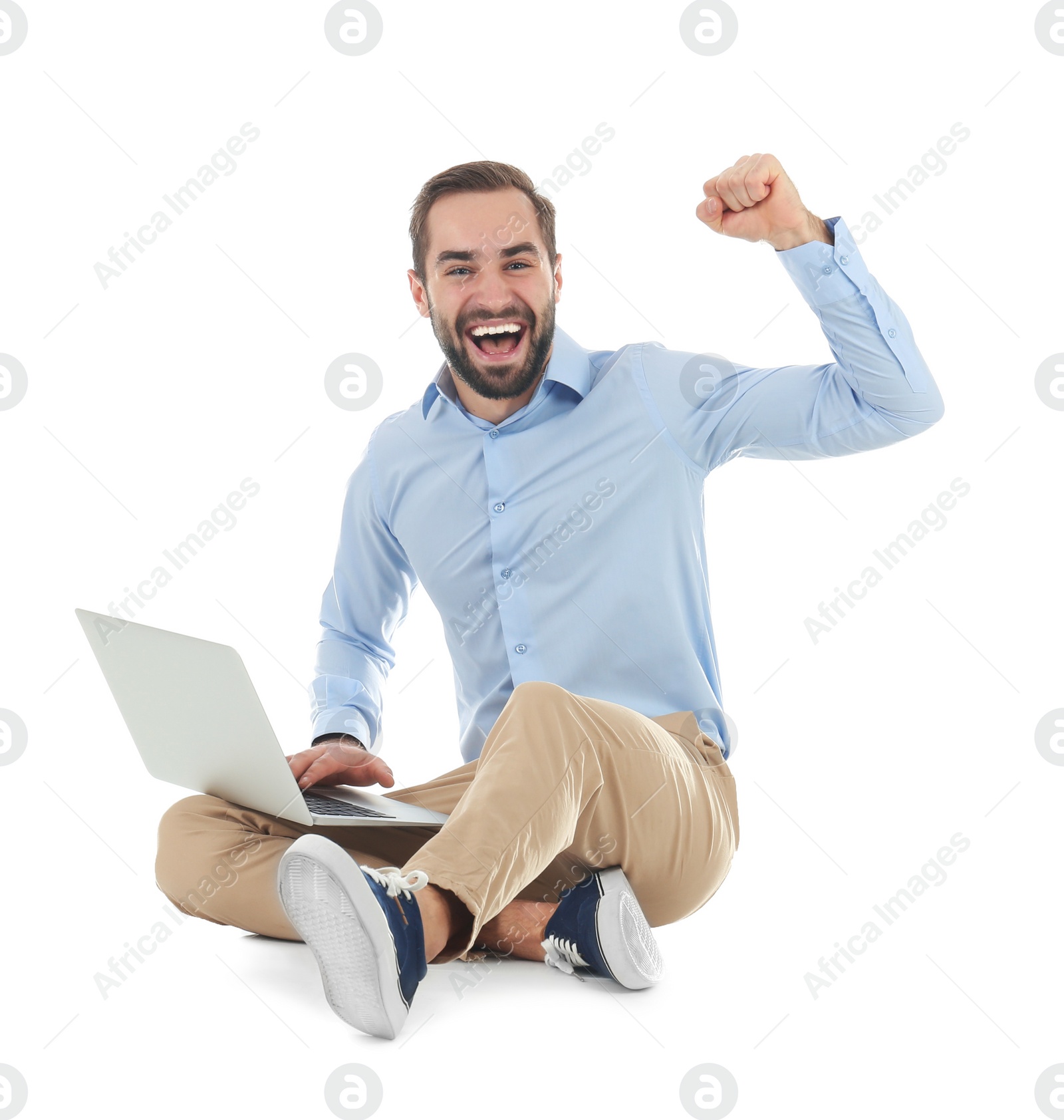 Photo of Emotional young man with laptop celebrating victory on white background